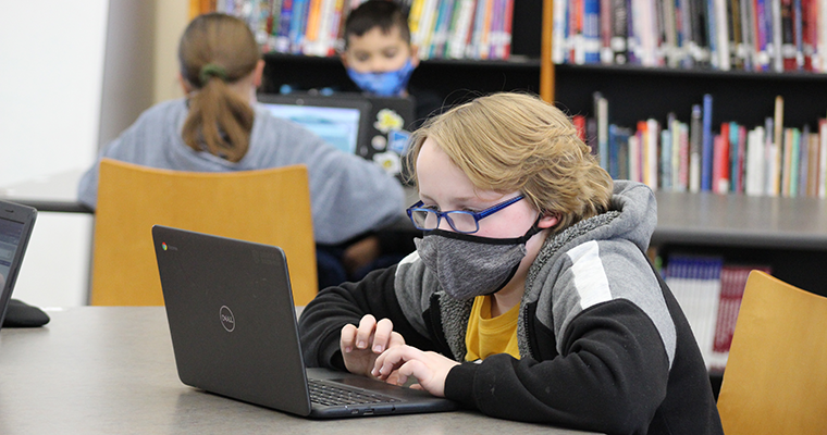 Masked student on laptop