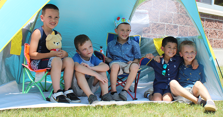 Students sitting in a tent smiling