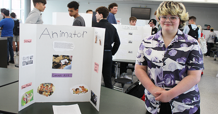 Student standing with their presentation