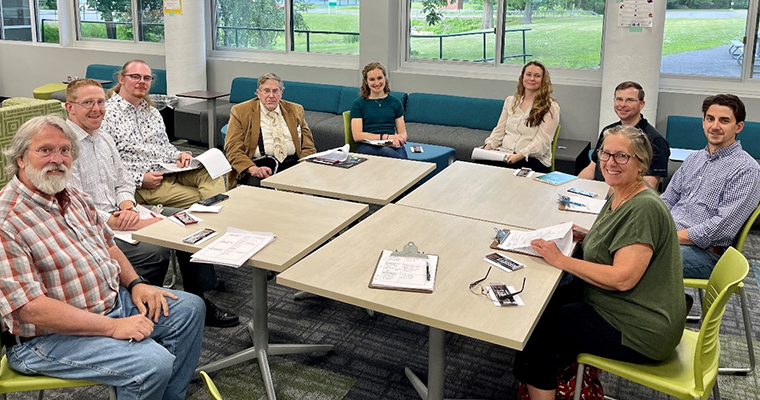 Judges for the civil engineering contest sitting around a table smiling