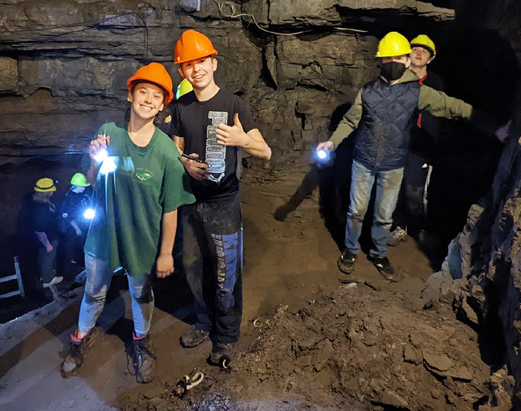 Students pose for photo in cave