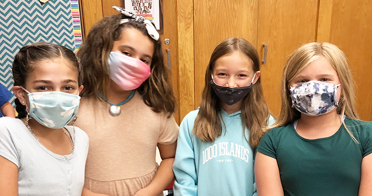 Four masked students posing