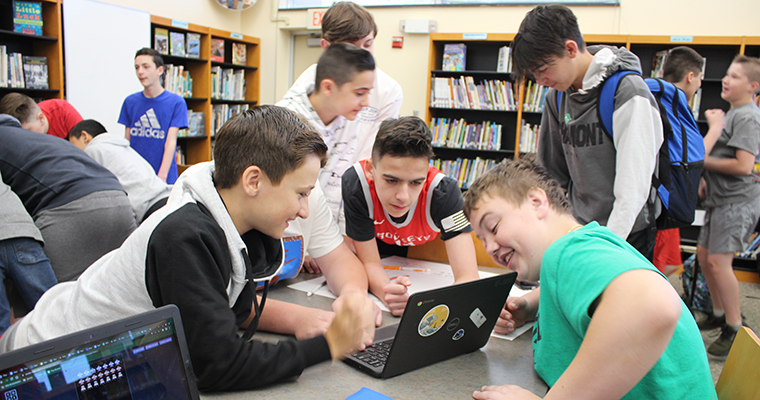 A group of students looking at a computer
