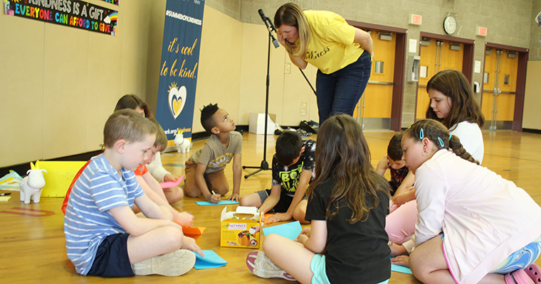 Students on the ground participating in kindness activity