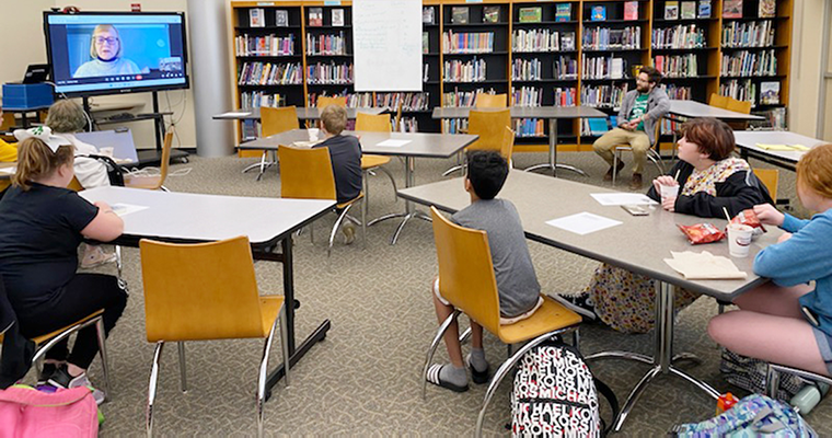 Students looking at author on a screen