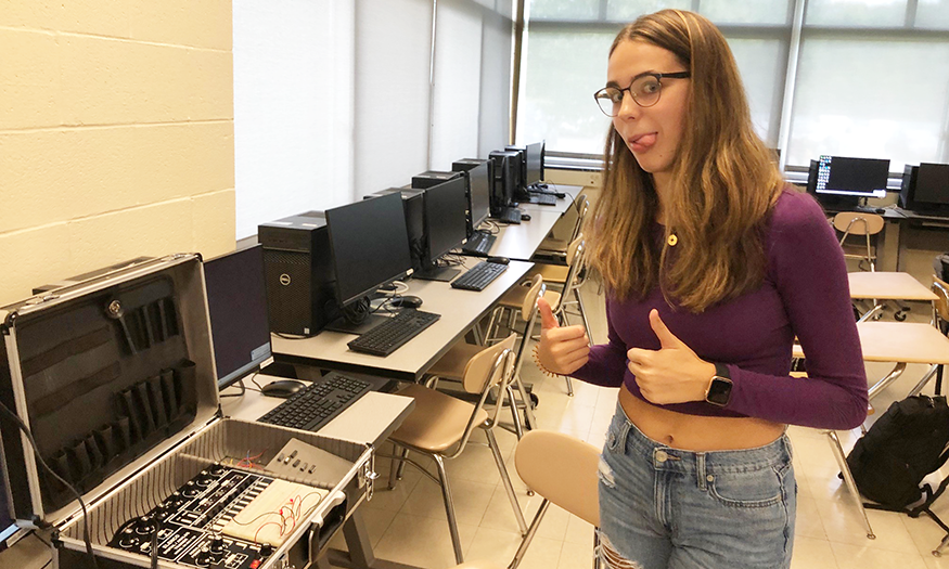 Students poses for photo with circuit