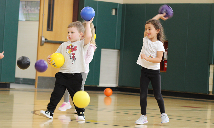 Students throw balls in gym class