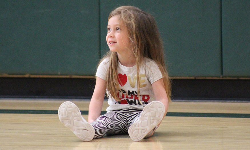 Students sits on gym floor