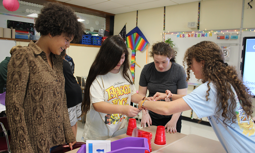 Students work together to stack cups