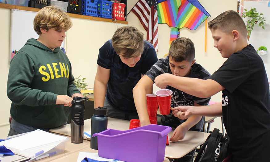 Students work together to stack cups