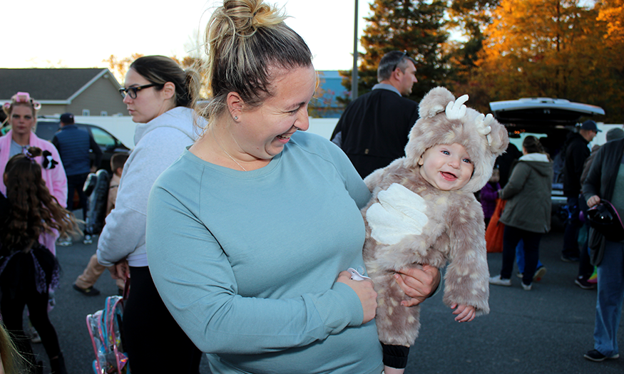 A mom holding a baby in costume