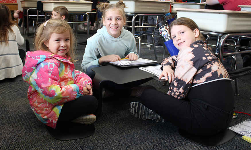 Girls sit on floor for photo