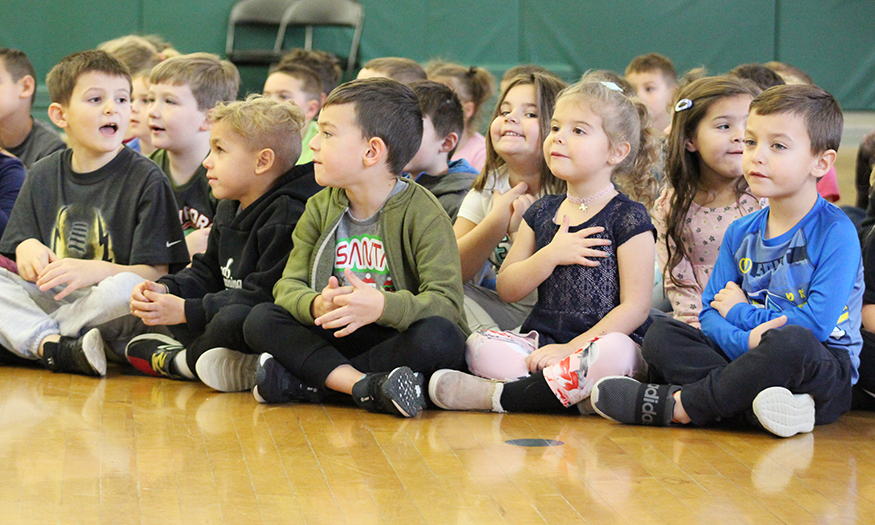 Students sit on floor during assembly