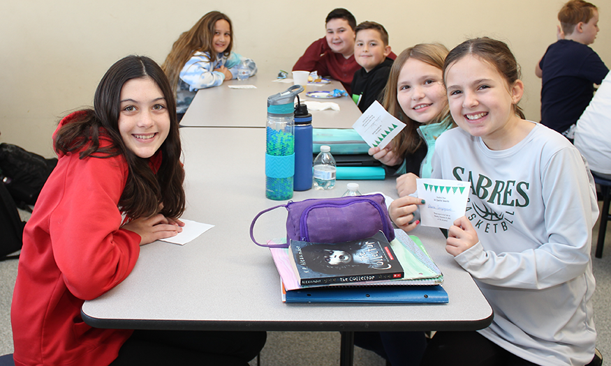 Students smile for a photo at lunch table