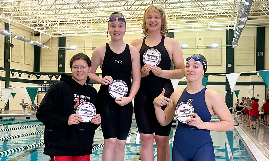 Swimmers pose for photo with awards