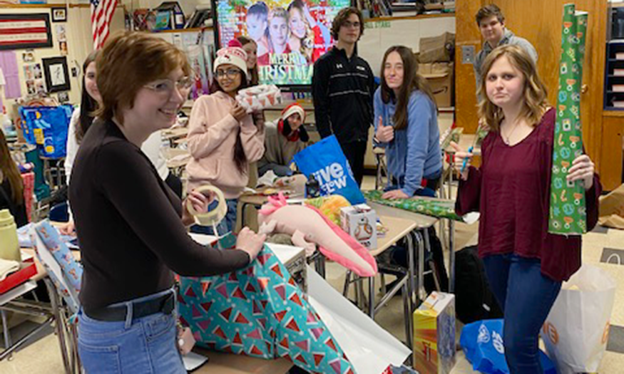 Students wrap presents in classroom
