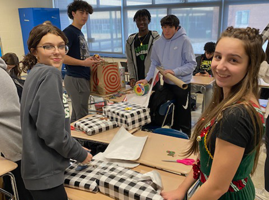 Students wrap presents in classroom