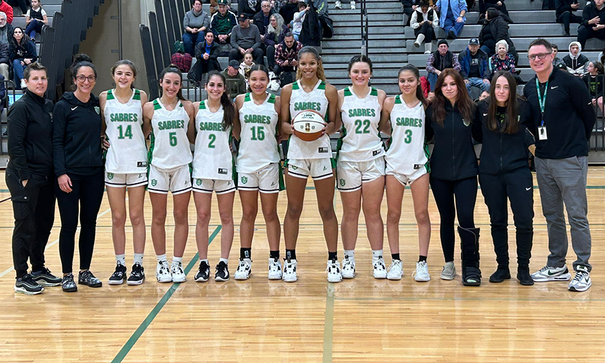 Girls Basketball team poses for photo on court