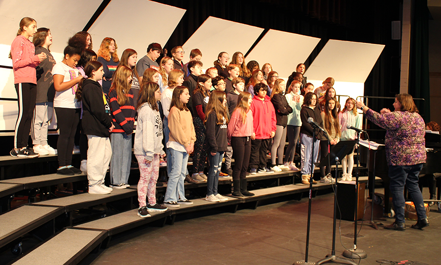 Chorus students practice on stage