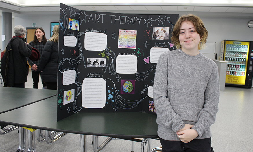 Student stands in front of presentation