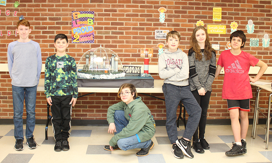 Students gather for group photo in front of project