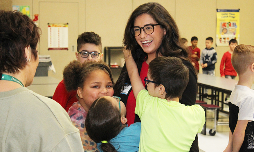 Meteorologist hugged by student