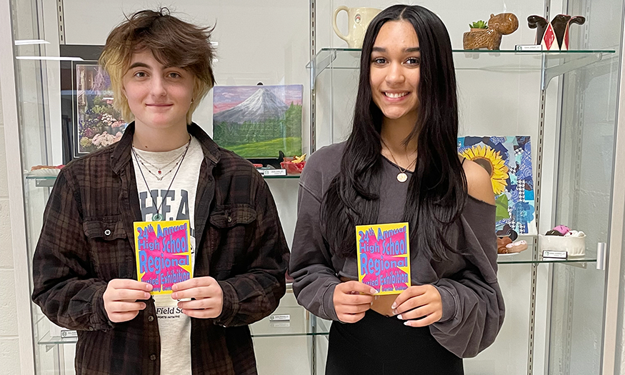 Two students pose for photo with awards