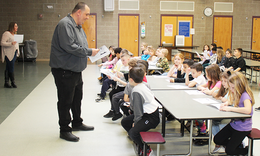 Bus driver speaks to students at table