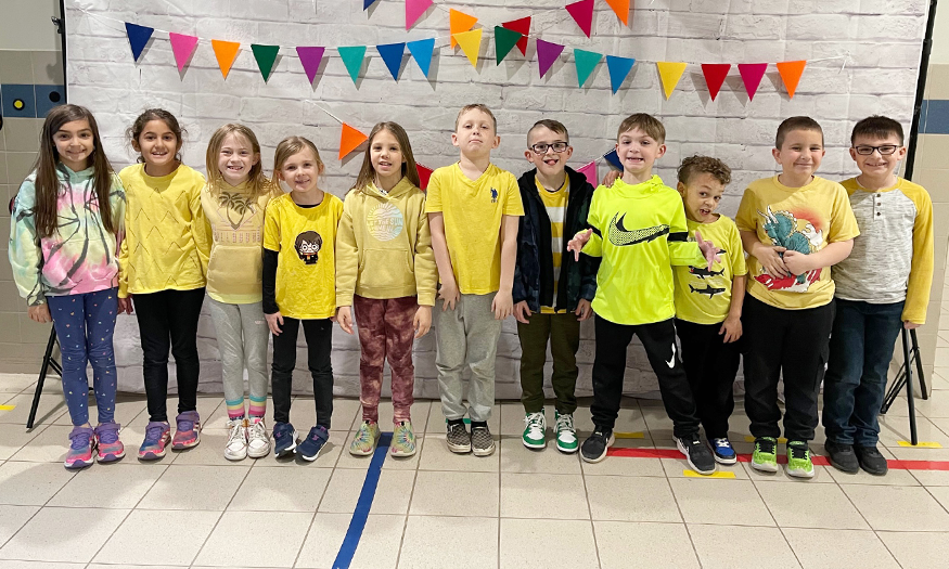 Students pose for photo with yellow shirts