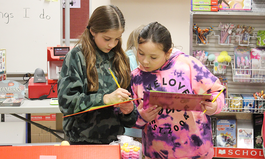 Students look at book together