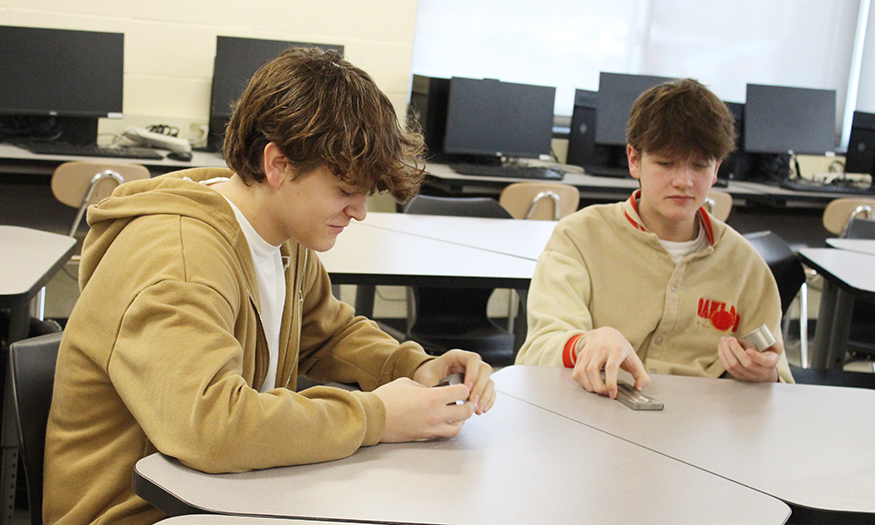 Students look at parts at desk