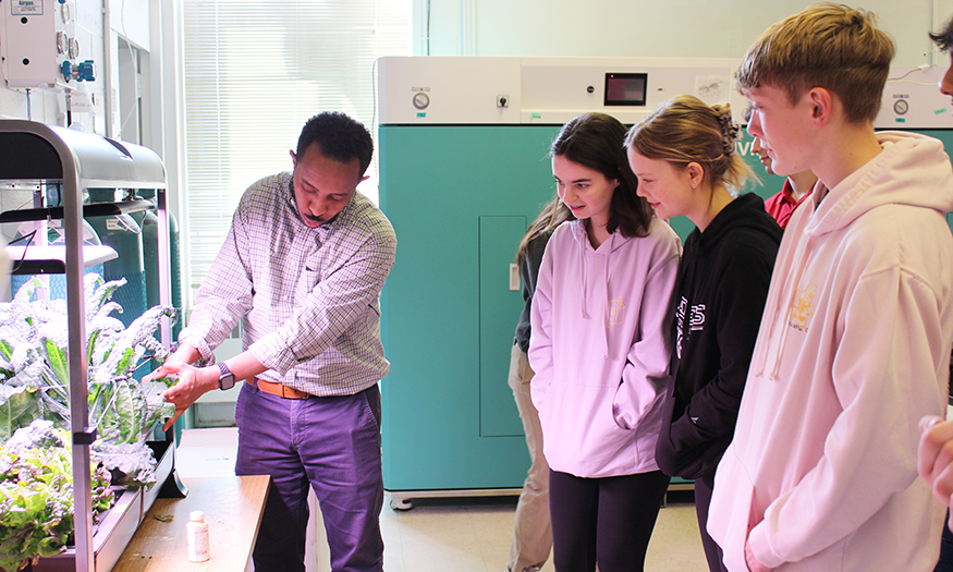 Students observe researcher in lab