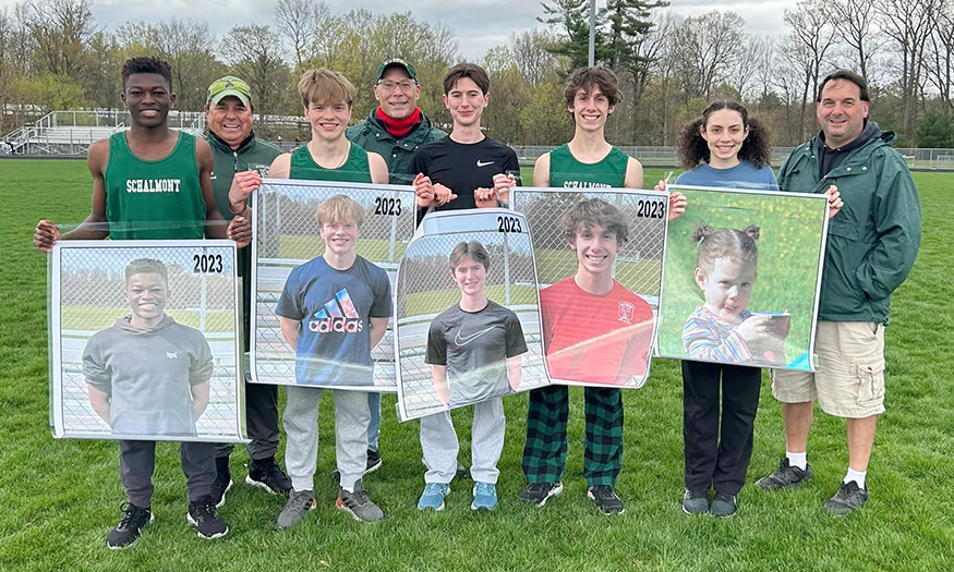 Group of student-athletes holding photos of themselves on Senior Night