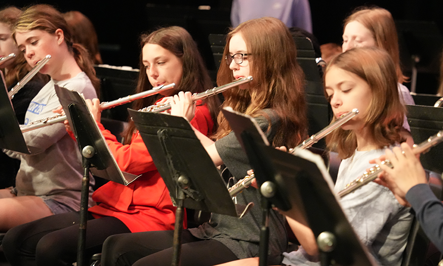 Students play instrumnents on stage