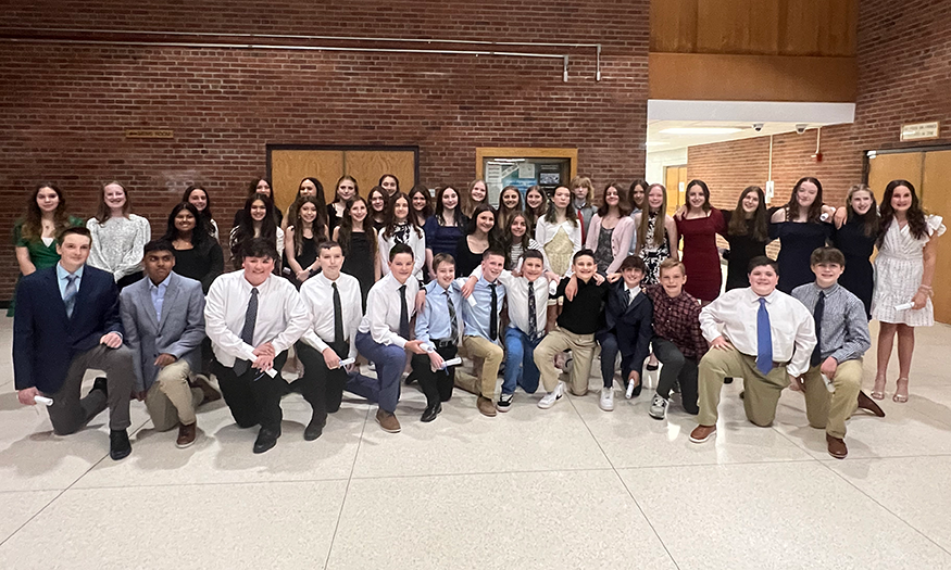 Large group of students pose for photo in lobby