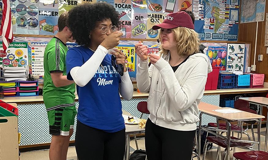 Two students eat food in class