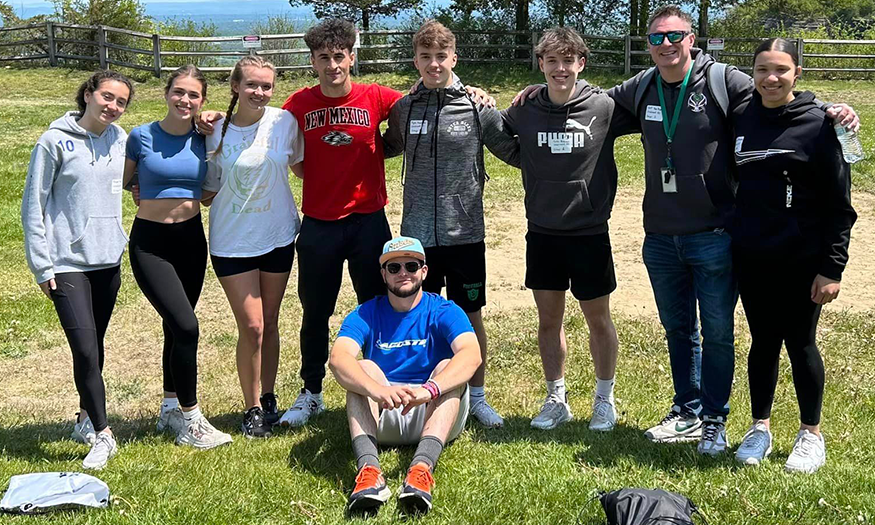 Group photo of students and coach outdoors