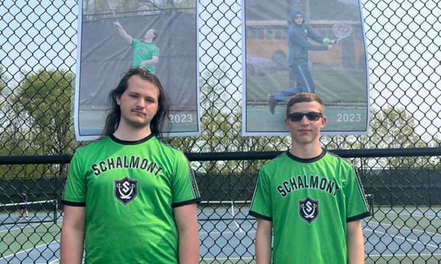 Two students in uniforms pose for photo