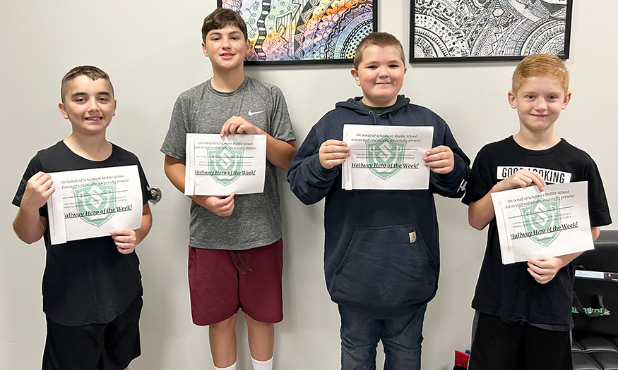 Four students pose for photos holding certificates