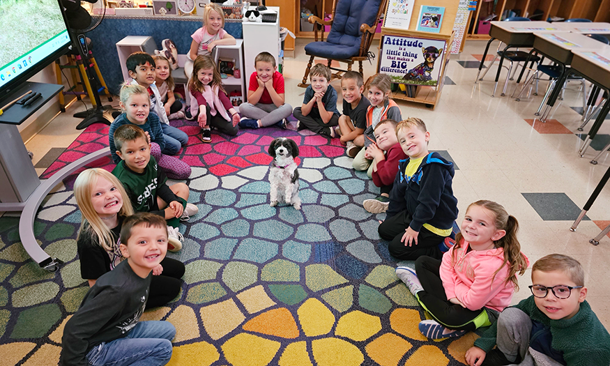 Therapy dog visits smiling group of students