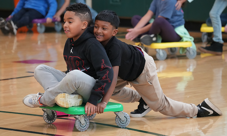 Students push each other on scooters