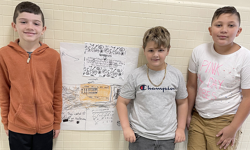 Students pose for photo with math posters