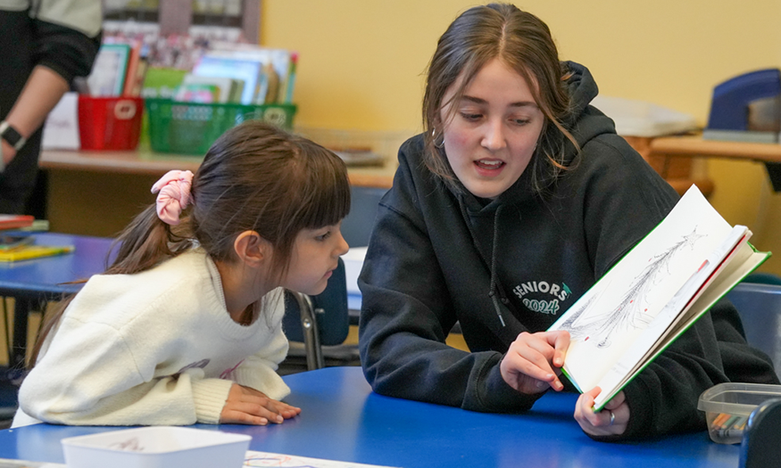 Student reads to a younger student