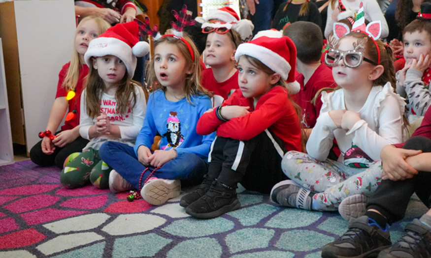 Students sing carols on floor