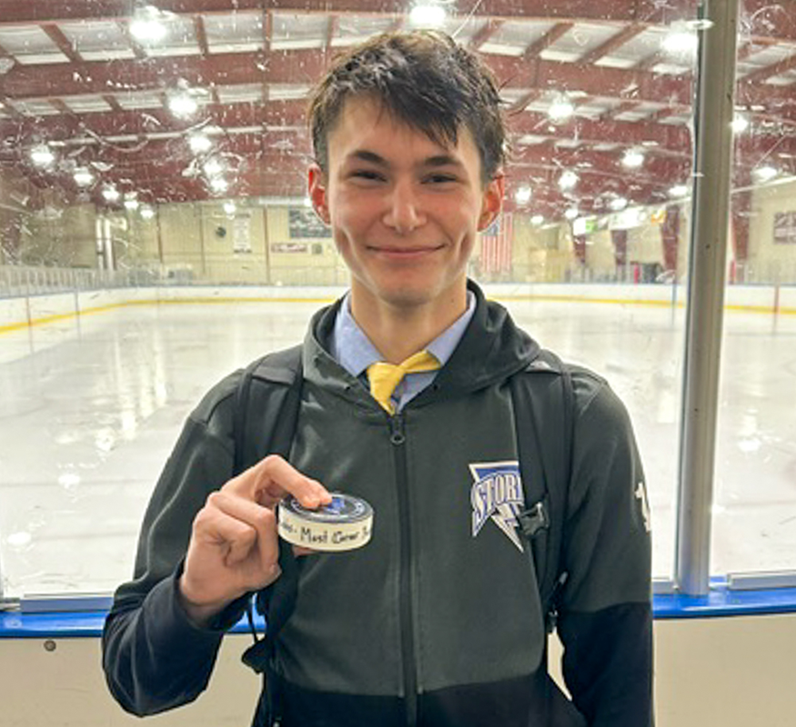 Student holds hockey puck