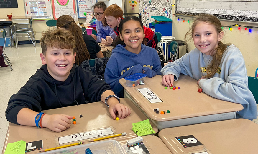 Students smile at desks