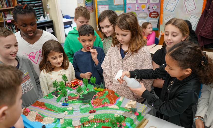 Students gather around model