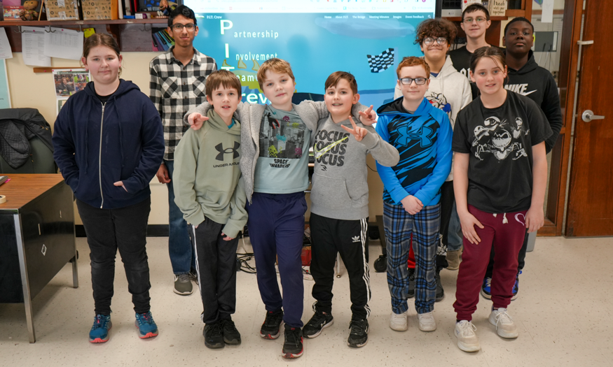 Group photo of students in front of screen