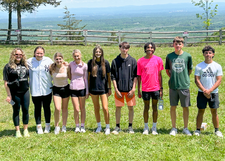 Group of students and coach pose for photo