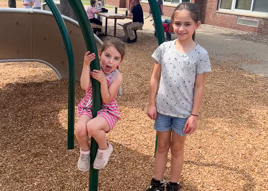 Students on playground pose for photo